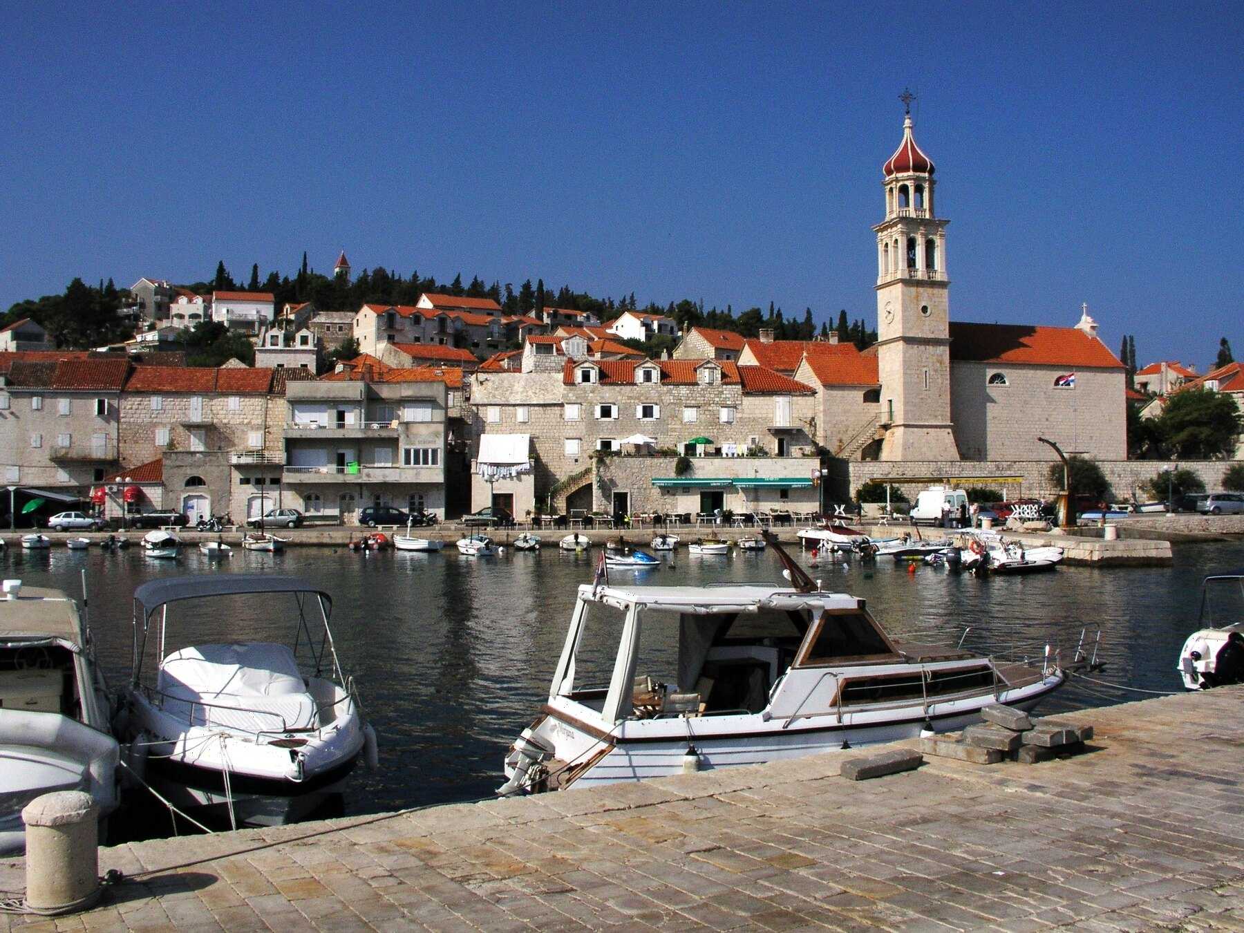 Le port de Sutivan et le clocher de son église sous un ciel bleu