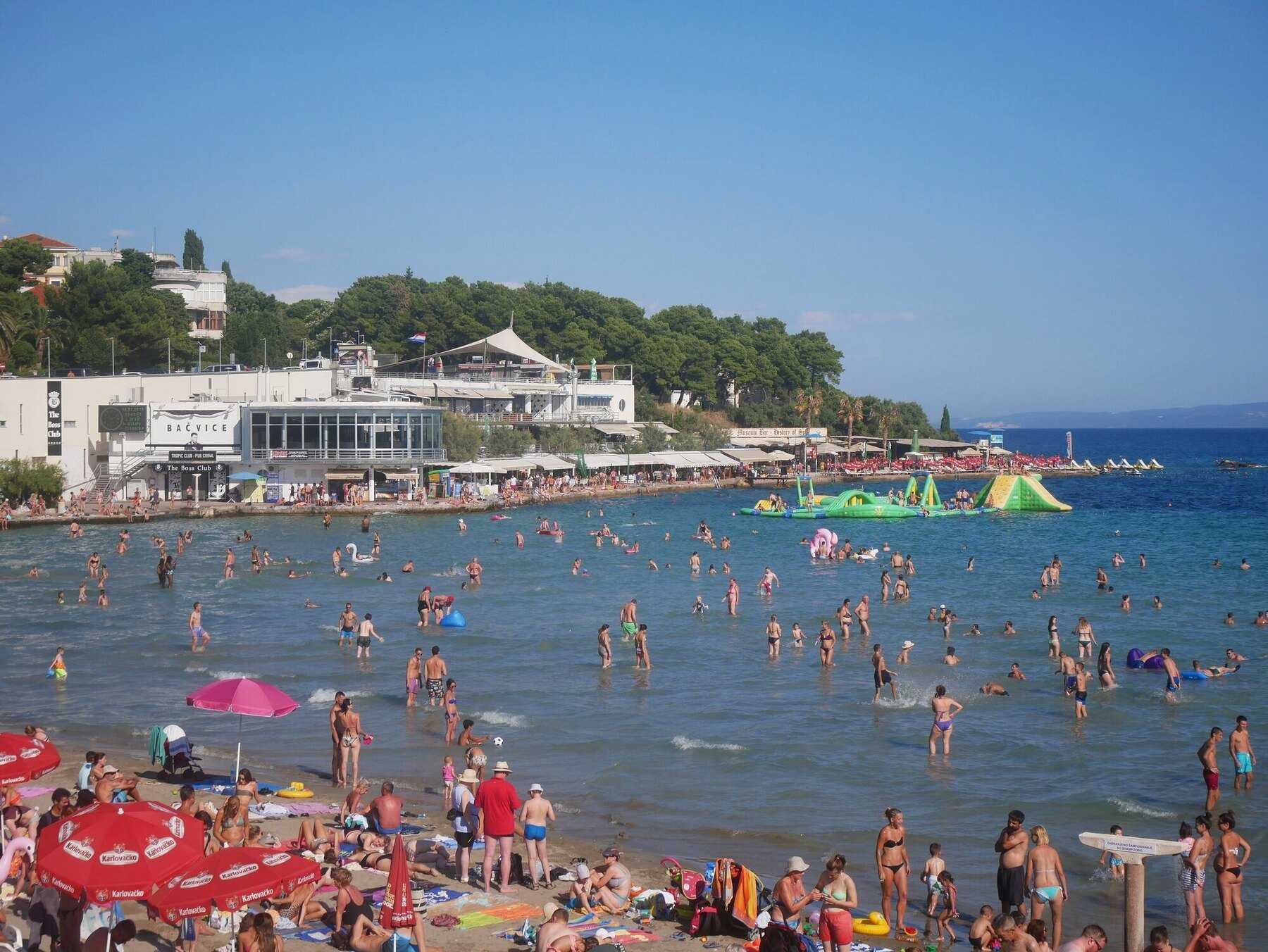 Familles et enfants dans l’eau peu profonde de la plage de Bačvice, à Split, un jour d’été