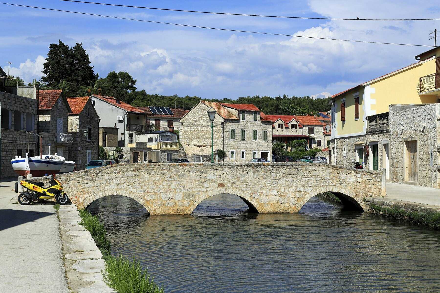 Un pont de pierre à trois arches sur le bras de mer de Vrboska