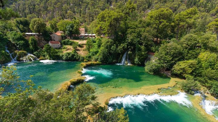 Bassins turquoise et cascades de Skradinski buk, avec les anciens moulins sur la rive, dans le parc national de Krka