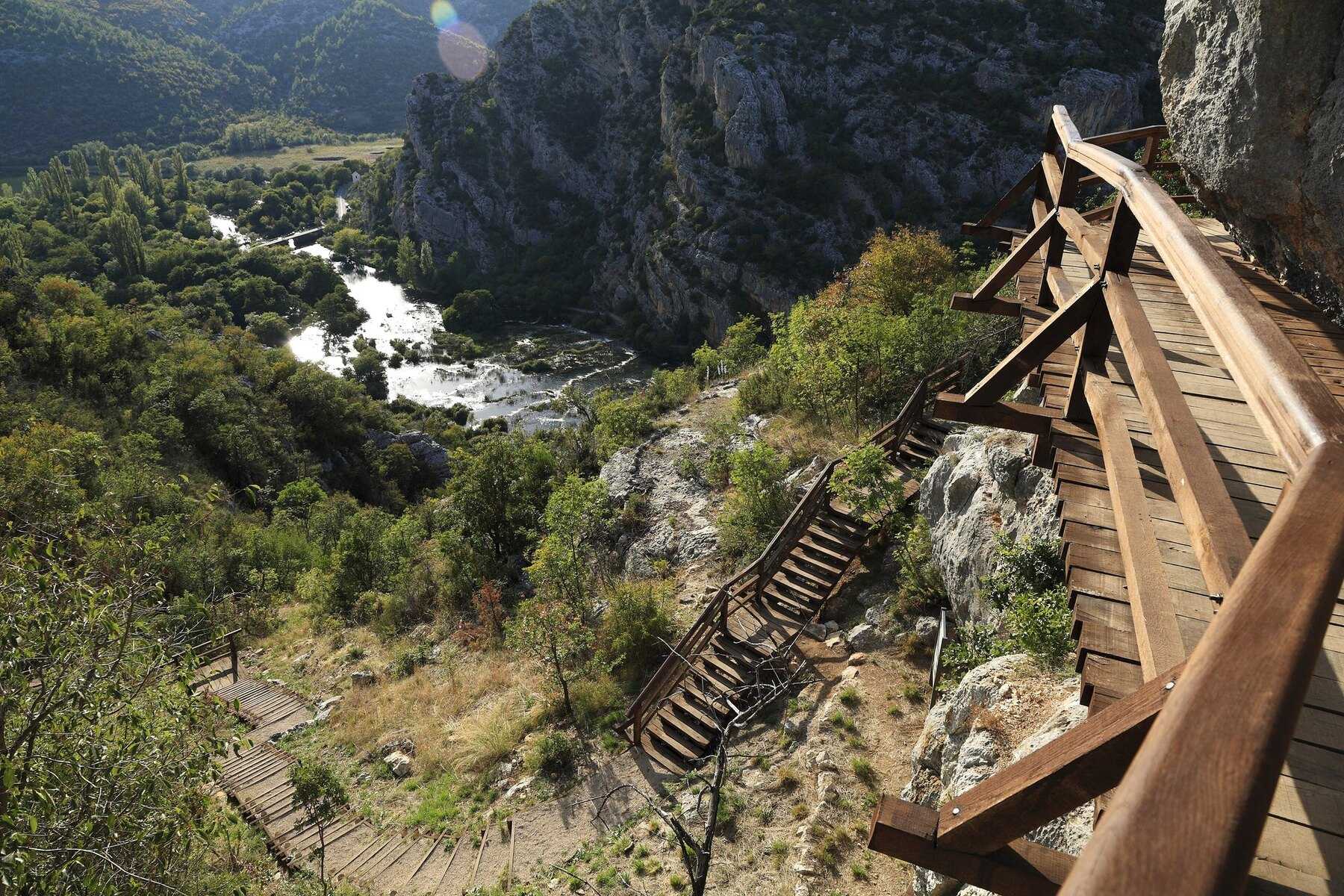 Escalier en bois qui monte vers la grotte Oziđana pećina, au-dessus des cascades des Ogrlice