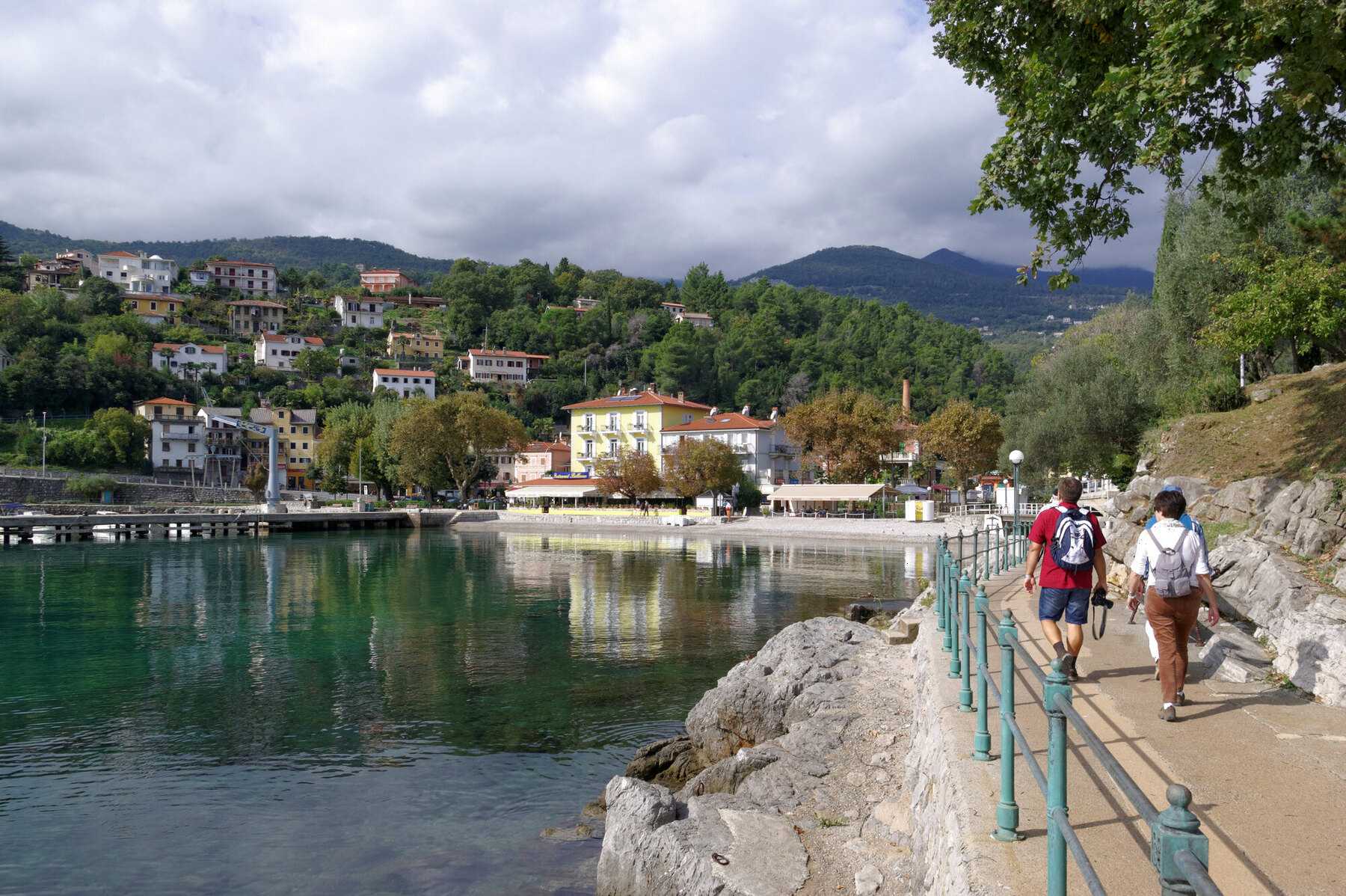 Promeneurs sur le Lungomare d'Opatija, chemin de bord de mer entre rochers et villas
