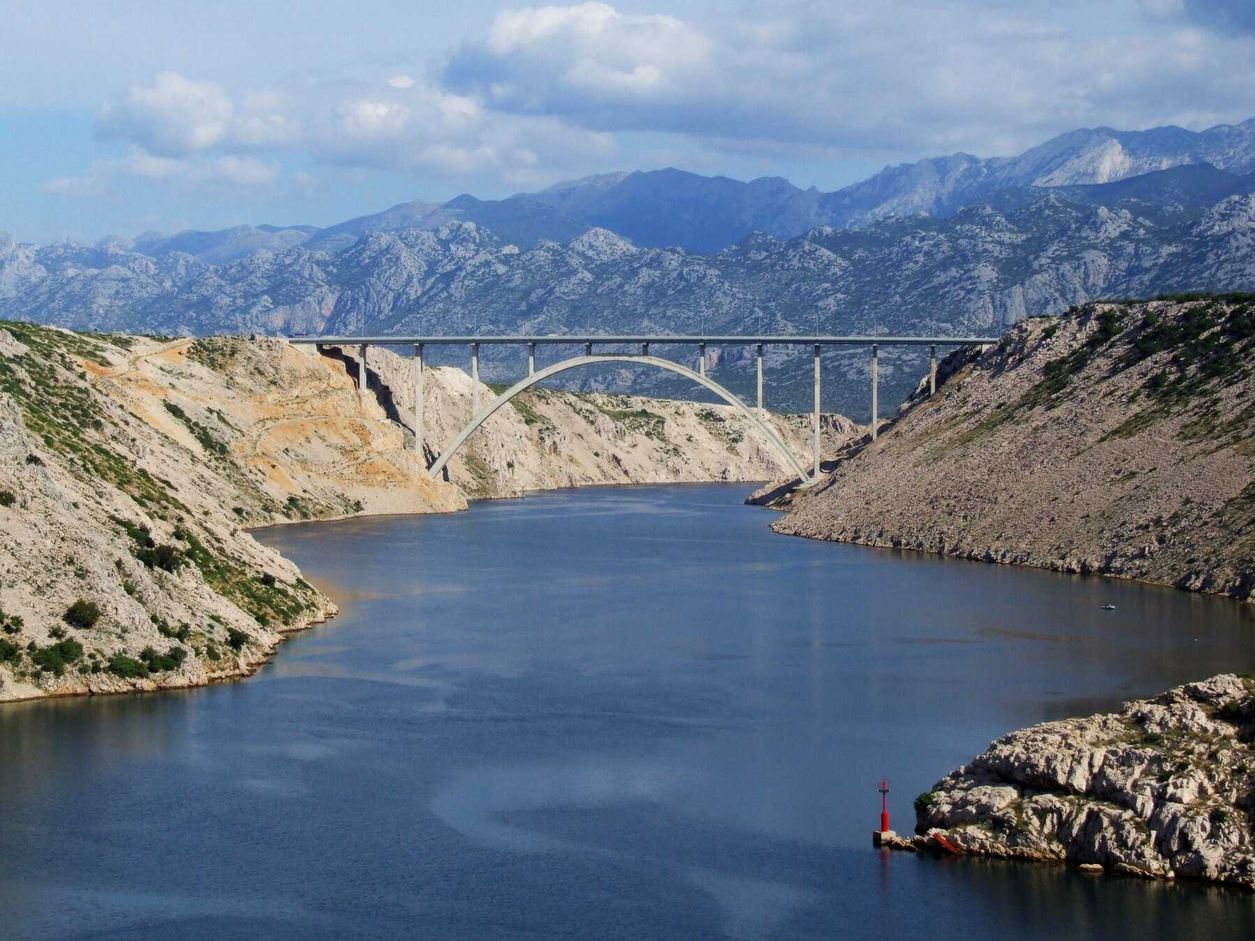 Le pont en arc de Maslenica, sur l’autoroute A1, au-dessus d’un bras de mer, avec le massif du Velebit au fond