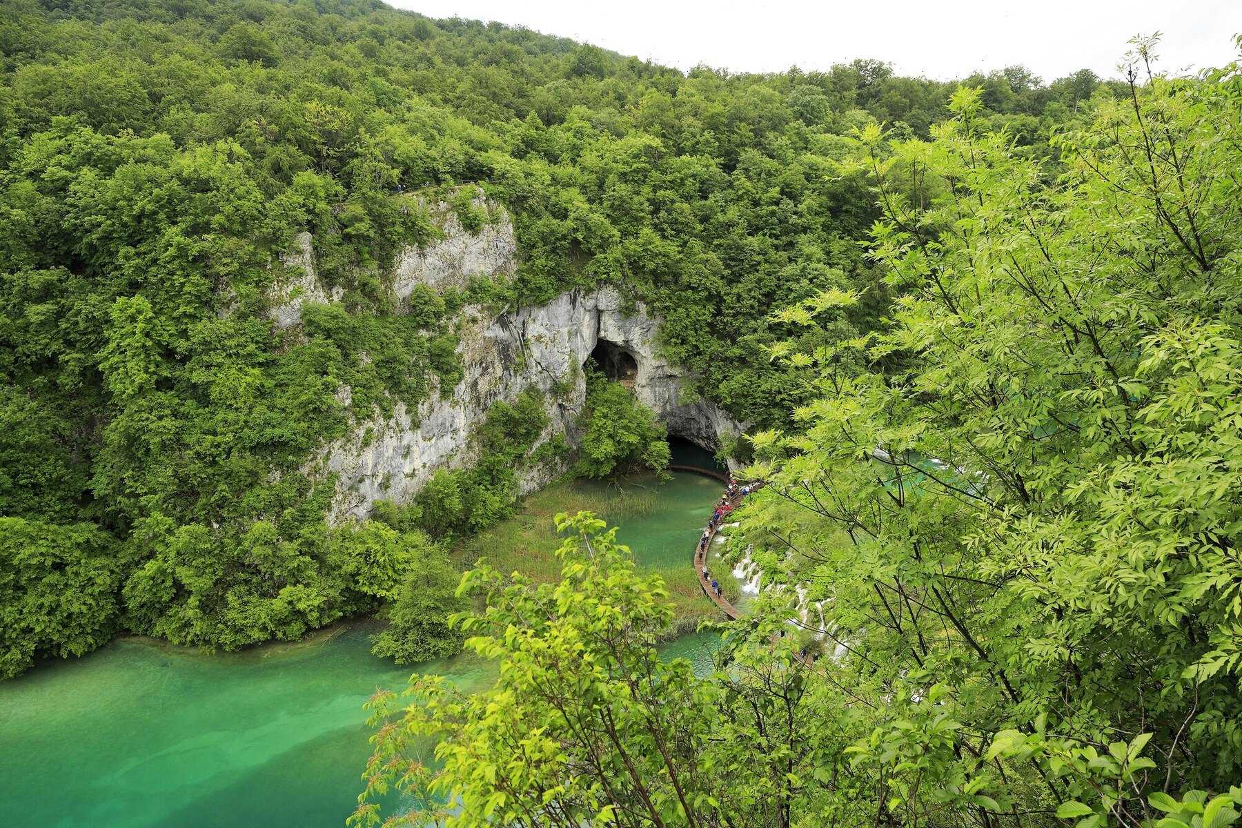 Entrée de la grotte Šupljara dans la paroi du canyon, au-dessus des eaux vertes des lacs inférieurs