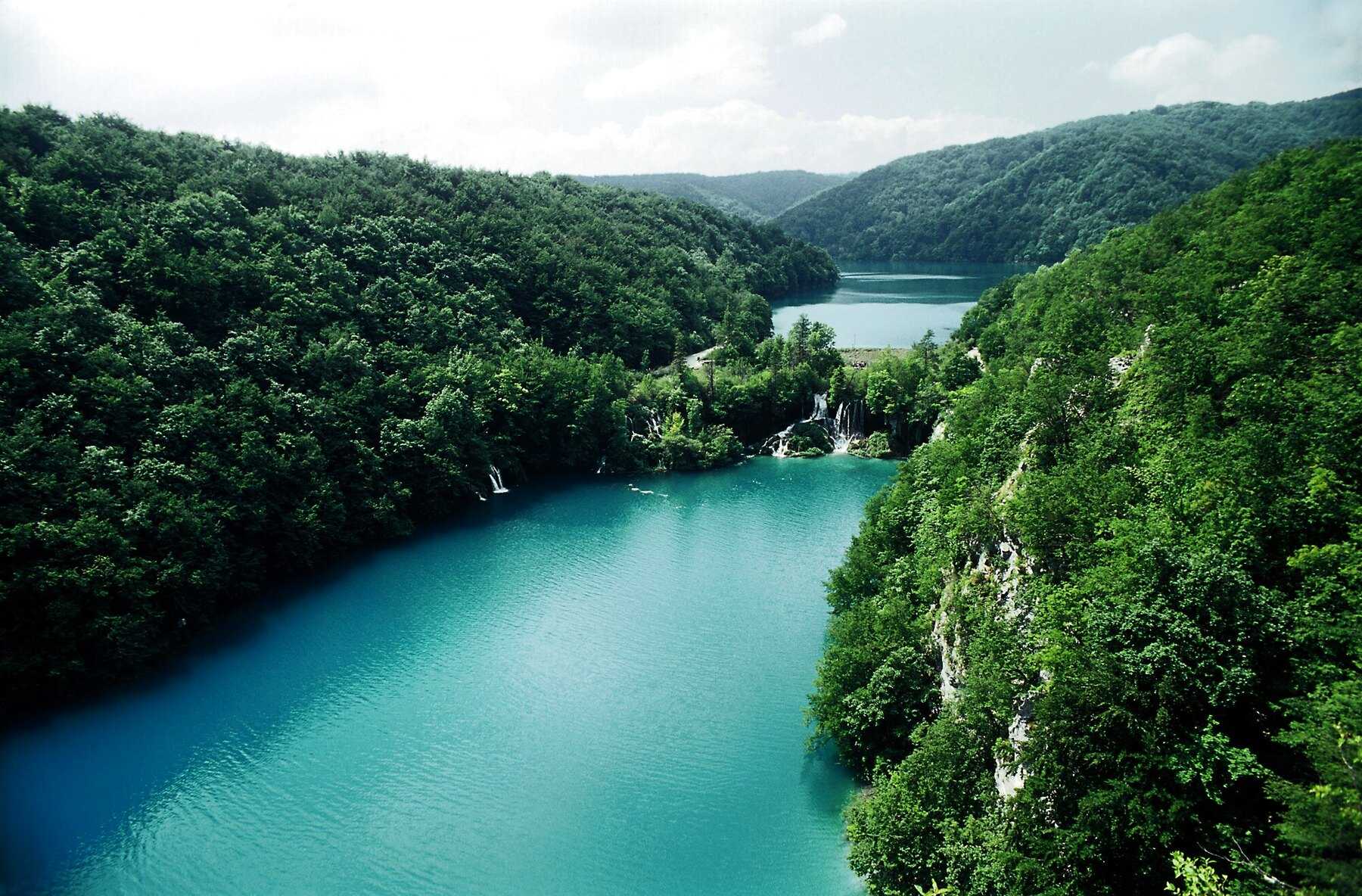 Le lac Milanovac, d'un bleu turquoise profond, encaissé entre des pentes boisées