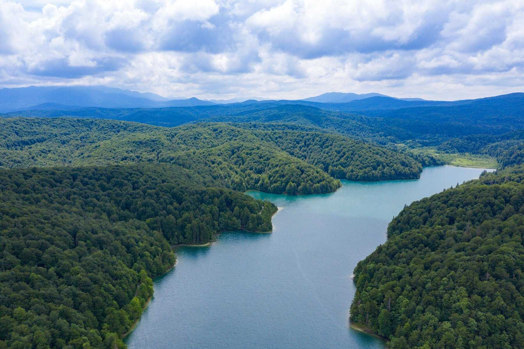 Vue aérienne du lac Prošćansko, long ruban d'eau entre des collines boisées, tout en haut du système des lacs